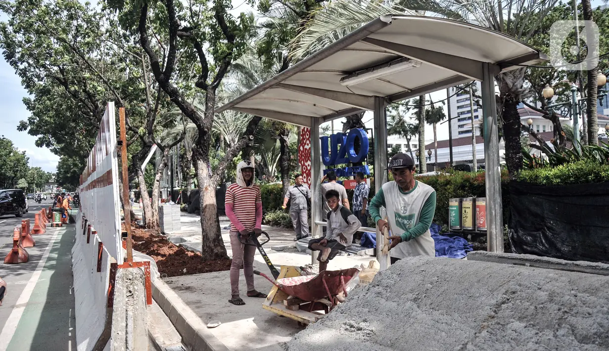 Pekerja menyelesaikan proyek revitalisasi trotoar di Jalan Medan Merdeka Selatan, Jakarta Pusat, Selasa (22/11/2022). Kepala Dinas Bina Marga DKI Jakarta Hari Nugroho mengatakan Rp 171 miliar RAPBD DKI Jakarta 2023 untuk membangun sekitar 20 kilometer trotoar di Ibu Kota. (merdeka.com/Iqbal S. Nugroho)