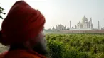 Seorang pria berdiri di seberang Taj Mahal dari tepi sungai Yamuna di Agra, Jumat (4/5). India tengah dirundung kekhawatiran akan perubahan warna pada salah satu situs bersejarah dunia, Taj Mahal karena terpapar polusi. (AFP/CHANDAN KHANNA)