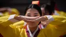 Seorang wanita muda melakukan ritual selama upacara “Coming of Age” di Namsan Hanok Village, Seoul, Senin (20/5/2019). Di Korea Selatan, Coming of Age Day atau hari kedewasaan dirayakan secara nasional setiap tahun pada hari Senin ketiga di bulan Mei. (Ed JONES/AFP)
