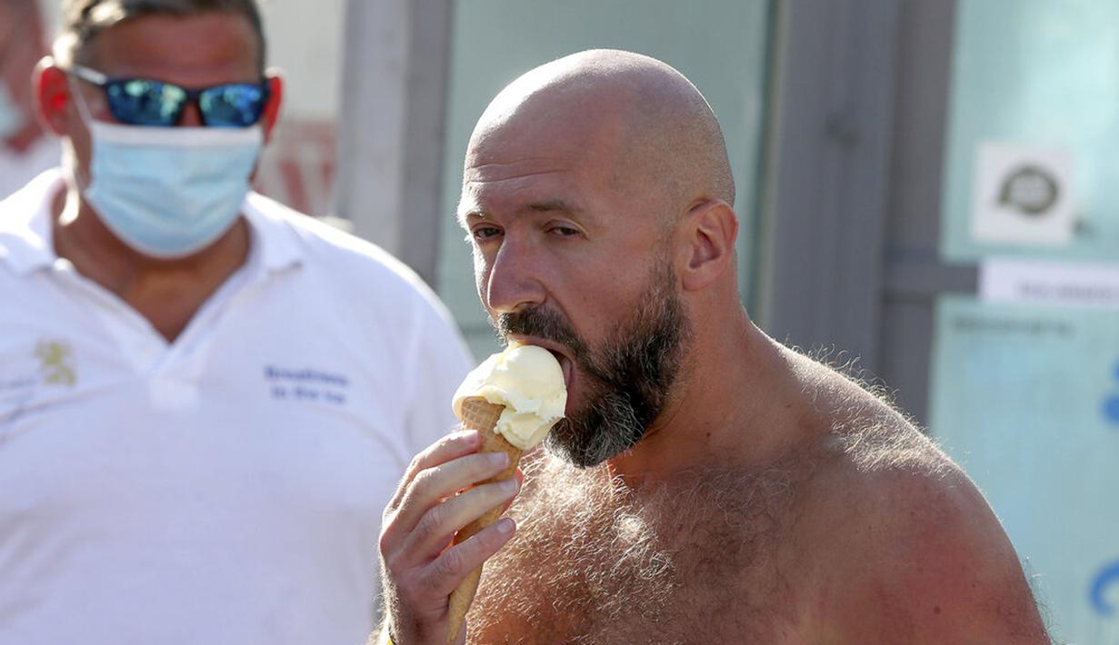 Perenang es Austria Josef Koeberl makan es krimusai memecahkan rekor dunia di Melk, Austria, Sabtu (5/9/2020). Josef Koeberl berhasil memecahkan rekor dunia dengan berendam dalam es selama 2 jam, 30 menit, dan 57 detik. (AP Photo/Ronald Zak)