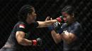 Petarung Indonesia, Priscilla Lumban Gaol, memukul petarung Filipina, Angelie Sabanal, pada laga One Championship di Istora Senayan, Jakarta, Sabtu (17/11). Priscilla meraih kemenangan angka di kelas atomweight. (Bola.com/Yoppy Renato)
