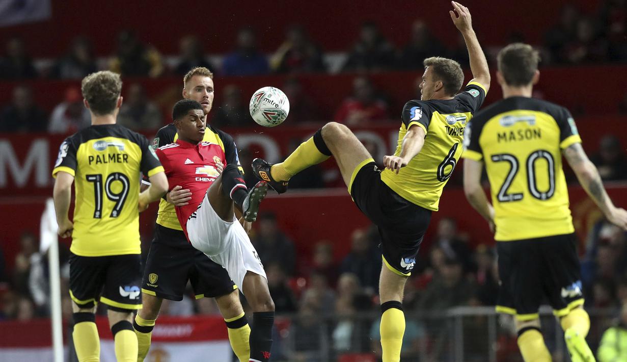 Aksi pemain Manchester United, Marcus Rashford (tengah) mengontrol bola dari adangan para pemain Burton Albion pada laga Piala Liga Inggris di Old Trafford, Manchester (20/9/2017). MU menang 4-1. (Martin Rickett/PA via AP)