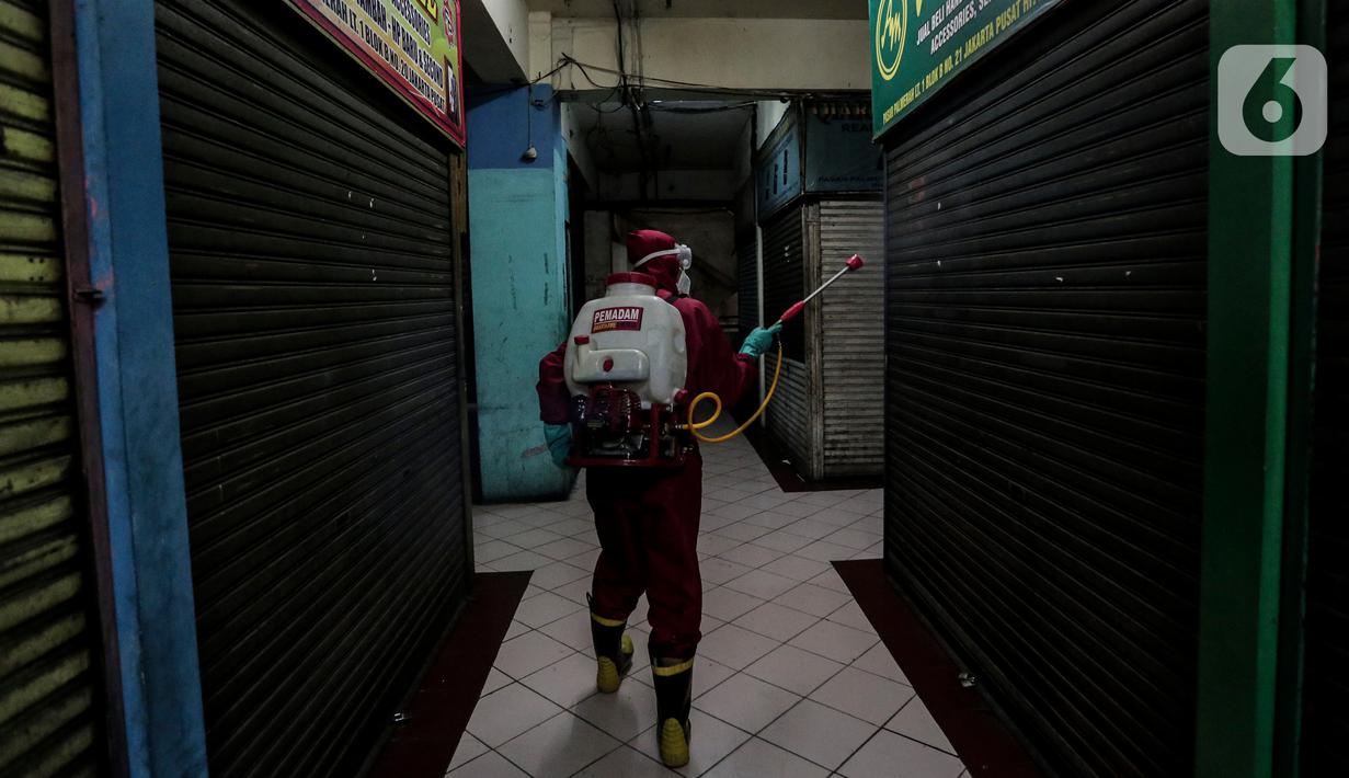 Petugas menyemprotkan Cairan Disinfektan di Pasar Palmerah, Jakarta, Kamis (25/6/2020). Penyemprotan dilakukan guna mencegah dan memutuskan mata rantai penyebaran Covid-19 di Area pasar Palmerah. (Liputan6.com/Johan Tallo)