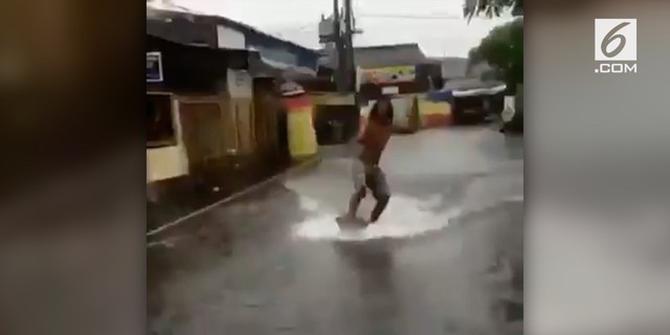 VIDEO: Kocak, Pria Ini Berselancar di Tengah Banjir