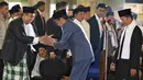 Presiden Joko Widodo atau Jokowi (tengah) menyalami imam sekaligus khatib salat Id Prof Dr Said Agil Husin Almunawar saat tiba di Masjid Istiqlal, Jakarta, Rabu (5/6/2019). (Liputan6.com/JohanTallo)