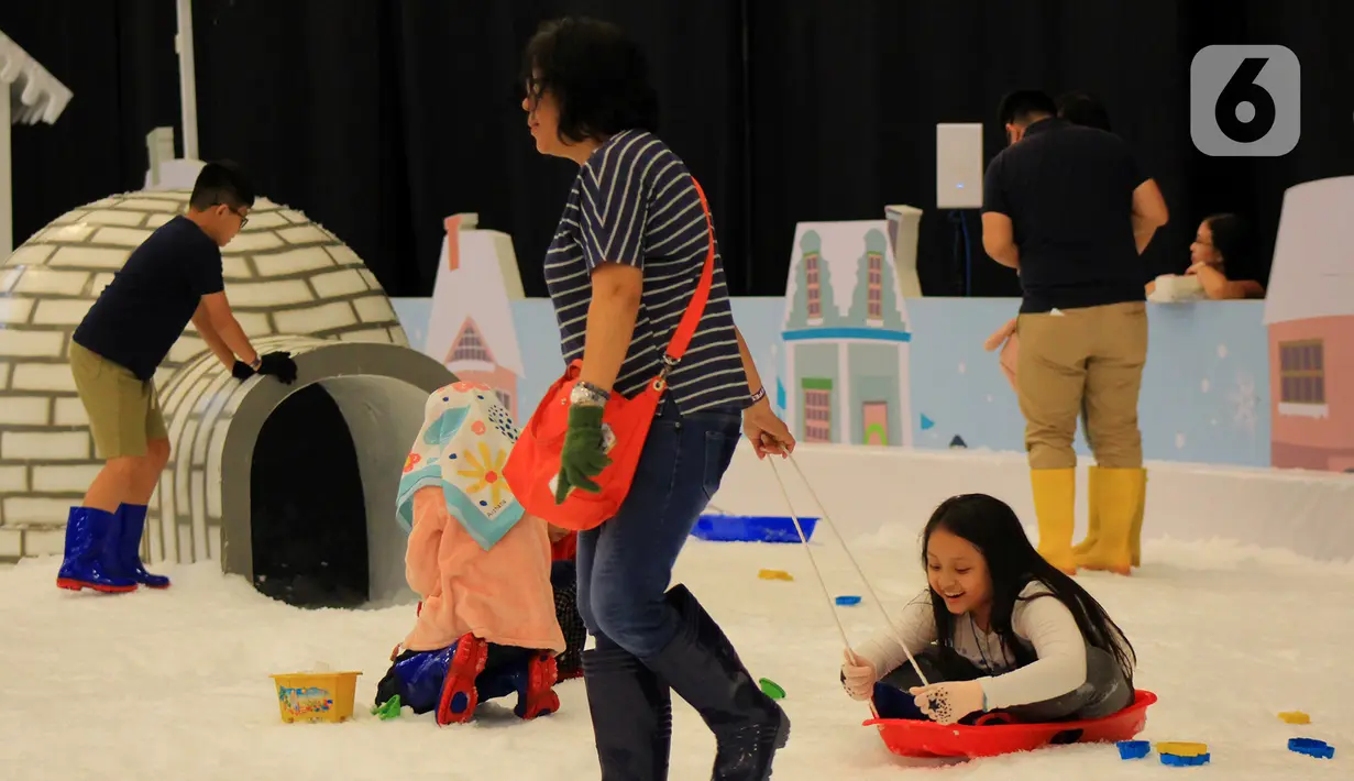 Seorang ibu bermain bersama anaknya di taman es ICEFest 2019 di ICE BSD City, Tangerang, Banten, Kamis (19/12/2019). Tiket masuk ICEFest 2019 dibanderol Rp 50 ribu per orang dan buka mulai pukul 10.00 - 22.00 WIB. (merdeka.com/Magang/Muhammad Fayyadh)