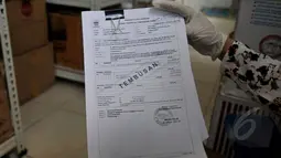 Penyidik Bareskrim memperlihatkan sebuah dokumen saat melakukan penggeledahan di Kantor PT Adhi Karya Pasar Minggu, Jakarta, Rabu (13/5/2015). (Liputan6.com/Johan Tallo) 