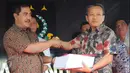 Dirtipidum Bareskrim Polri Brigjen Agus Andrianto (kiri) menyerahkan berkas perkara tahap 1 kepada Ketua Jaksa Peneliti Berkas Perkara Ahok, Ali Mukartono di Kejaksaan Agung, Jakarta, Jumat (25/11). (Liputan6.com/Helmi Afandi)