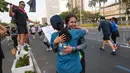 Seorang penonton memeluk temannyanya yang mengikuti Jakarta Running Festival (JRF) 2026 di kawasan Jalan Jenderal Sudirman, Jakarta, Sabtu (24/10/2026). (KLY/Budy Santoso)