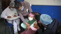 Seorang anak menerima suntikan vaksin covid-19 Sinopharm di La Paz, Bolivia, Kamis (9/12/2021). Presiden Bolivia Luis Arce mengizinkan vaksinasi anak berusia antara 5 hingga 11 tahun untuk menekan laju peningkatan infeksi COVID-19 di negara itu. (LUIS GANDARILLAS / AFP)