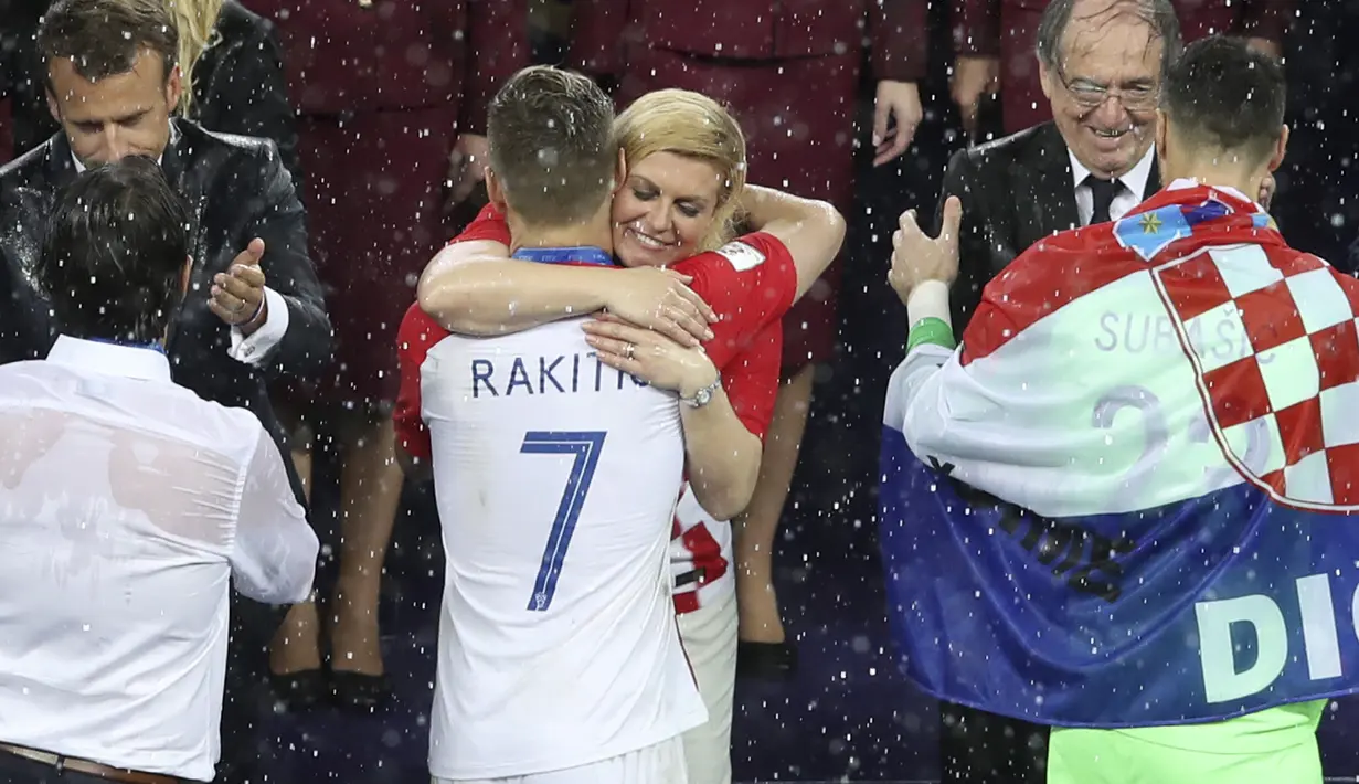 Kolinda Grabar-Kitarovic memeluk Ivan Rakitic usai laga final Piala Dunia 2018 di Luzhniki Stadium, Moskow, Rusia, (15/7/2018). Meski Kroasia kalah Kolinda tetap tersenyum manis. (AP/Thanassis Stavrakis)