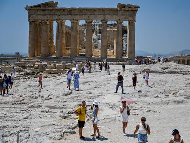 Wisatawan mengunjungi Acropolis di Athena, Yunani, Minggu (24/7/2022). Negara ini berada dalam cengkeraman gelombang panas yang dimulai pada 23 Juli dan akan berlangsung beberapa hari. Suhu diperkirakan akan mencapai 42 derajat Celcius (107 derajat Fahrenheit) di beberapa daerah.
(Louisa GOULIAMAKI / AFP)