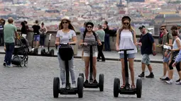 Sejumlah turis wanita menggunakan segway untuk menikmati keindahan kota dan bangunan tua di pusat kota Praha, Ceko, Selasa (19/7). Segway adalah kendaraan personal listrik beroda 2 yang mampu menyeimbangkan sendiri. (REUTERS/David W Cerny)