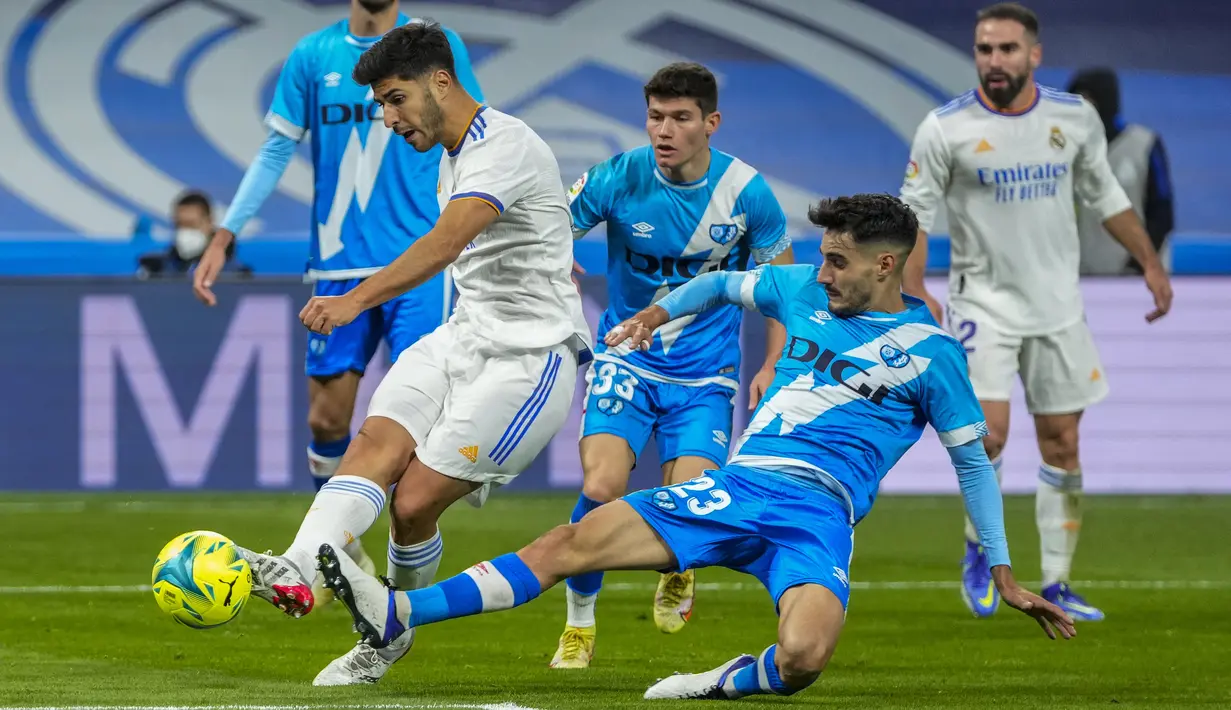 Penyerang Real Madrid Marco Asensio berebut bola dengan gelandang Rayo Vallecano, Oscar Valentin pada pekan ke-13 Liga Spanyol 2021/22 di Santiago Bernabeu, Minggu (7/11/2021) dini hari WIB. Real Madrid berhasil mengantongi tiga poin setelah menekuk Rayo Vallecano 2-1. (AP Photo/Manu Fernandez)