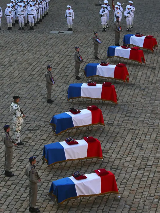 Prajurit  berdiri dekat peti jenazah tentara Prancis yang tewas dalam kecelakaan helikopter di Mali, Paris, Senin (2/12/2019). Sebanyak 13 tentara tewas setelah dua helikopter yang ditumpangi bertabrakan dalam operasi melawan miltan di Mali. (AP Photo/Rafael Yaghobzadeh)