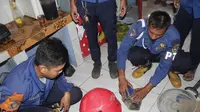 Tim reaksi cepat Dinas Pemadam Kebakaran dan Penanggulangan Bencana (DPKPB) Kabupaten Purwakarta saat mengevakuasi belasan ular kobra di permukiman warga. (Liputan6.com/ Abramena)