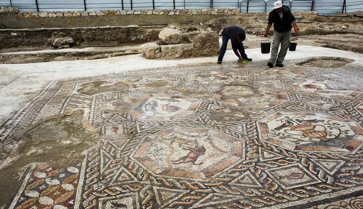 Seorang peneliti sejarah kuno membersihkan sebuah gambar yang ada pada lantai sebuah peradaban pada 1.700 tahun yang lalu di Tel Aviv, Israel, Senin (16/11/2015). Tempat ini telah ada pada zaman Romawi dan periode Bizantium. (REUTERS/Nir Elias)