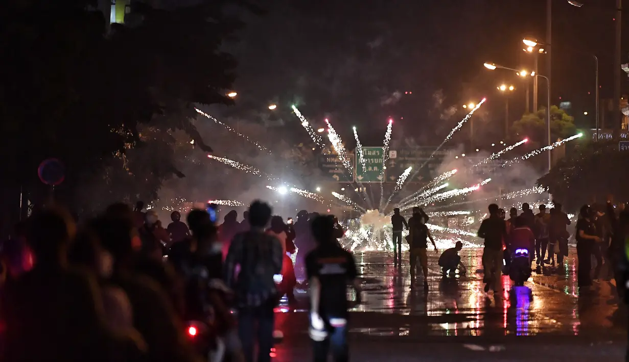 Pengunjuk rasa anti-pemerintah meluncurkan petasan ke arah polisi selama demonstrasi di Bangkok, Thailand, Minggu (6/9/2021). (AFP/Lillian Suwanrumpha)