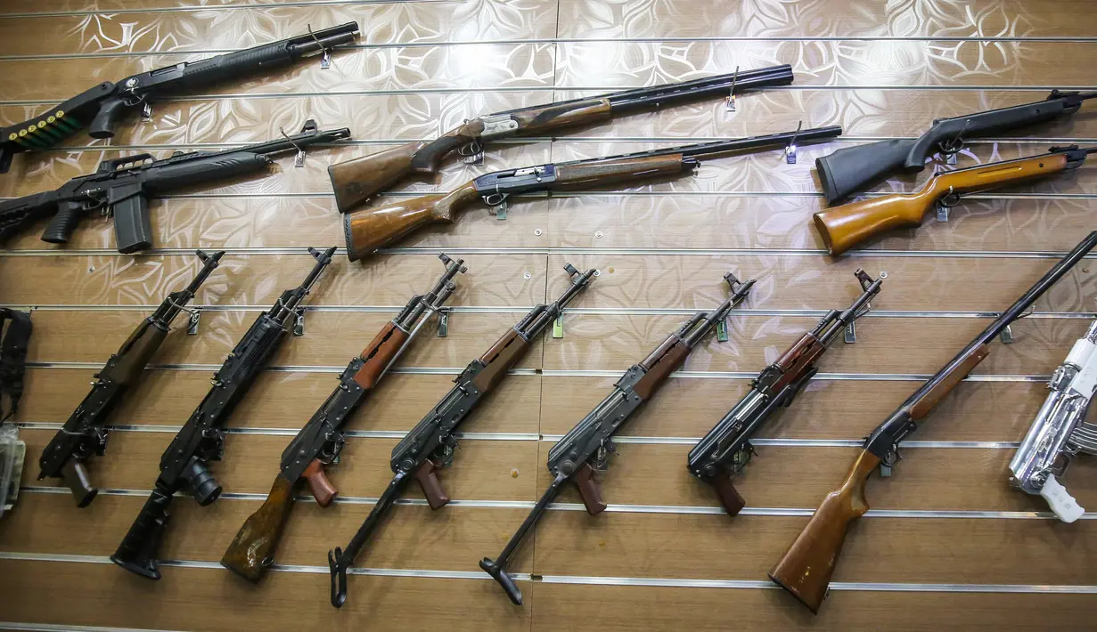 Bermacam-macam senapan tergantung di dinding sebuah toko senjata berlisensi di ibu kota Irak, 24 September 2018. Pertama kalinya selama beberapa dekade terakhir, senjata semi otomatis dan pistol dapat dibeli secara legal di Baghdad. (AFP/AHMAD AL-RUBAYE)