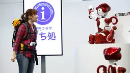 Petugas memperagakan robot humanoid 'EMIEW 3' yang dapat membantu turis dari negara asing di Tokyo, Jepang, (8/4). Robot ini dikembangkan untuk memberikan layanan dan bimbingan yang diperlukan di toko-toko dan fasilitas umum. (REUTERS/Issei Kato)