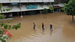 Sejumlah pengurus sekolah SMAN 8 Jakarta mengecek banjir kiriman yang menerjang sekolah mereka di Kelurahan Bukit Duri, Tebet, Jakarta, (8/3/2016). Akibat banjir tersebut, sekolah terpaksa diliburkan. (Liputan6.com/Gempur M Surya) 