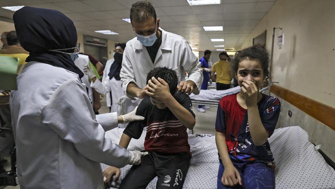 Anggota keluarga Palestina Abu Dayer menangis di rumah sakit Al-Shifa setelah kematian anggota keluarga dalam serangan udara Israel di Kota Gaza, Senin (17/5/2021). Tercatat ada 212 penduduk Jalur Gaza, Palestina yang kehilangan nyawa di antaranya 61 korban merupakan anak-anak. (MAHMUD HAMS/AFP)