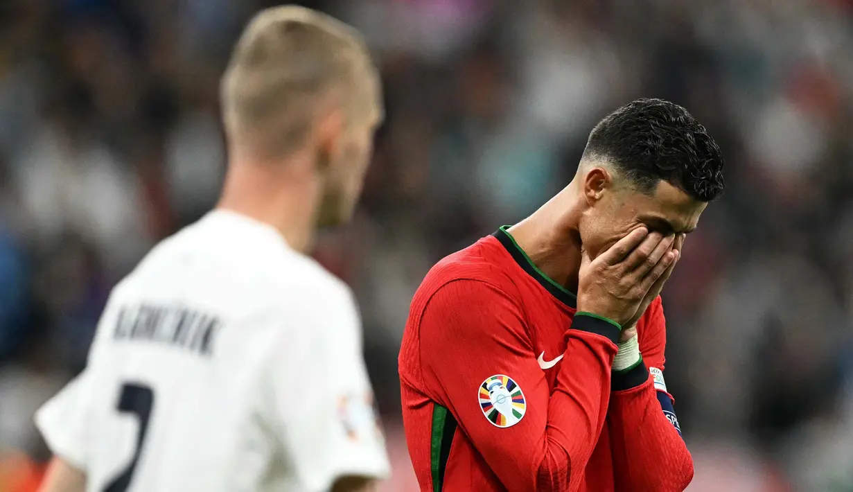 Cristiano Ronaldo tampil sebagai eksekutor dan melepaskan tembakan ke arah kanan penjaga gawang Slovenia, Jan Oblak. (PATRICIA DE MELO MOREIRA/AFP)