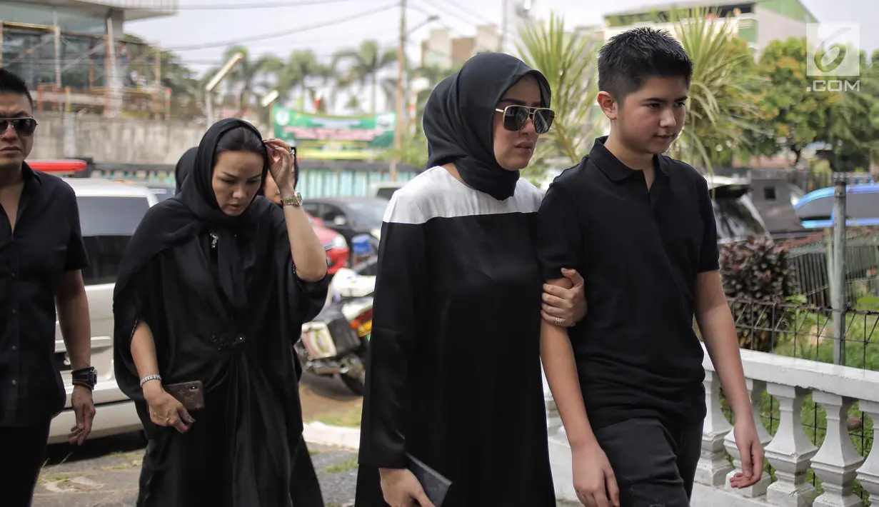 Artis Olla Ramlan menuju masjid sekitar rumah duka untuk menyalatkan jenazah ayahnya Muhammad, Jakarta, Selasa (5/6). Usai disalatkan, jenazah M. Ramlan diantarkan ke tempat peristirahatan terakhirnya di TPU Tanah Kusir. (Liputan6.com/Faizal Fanani)
