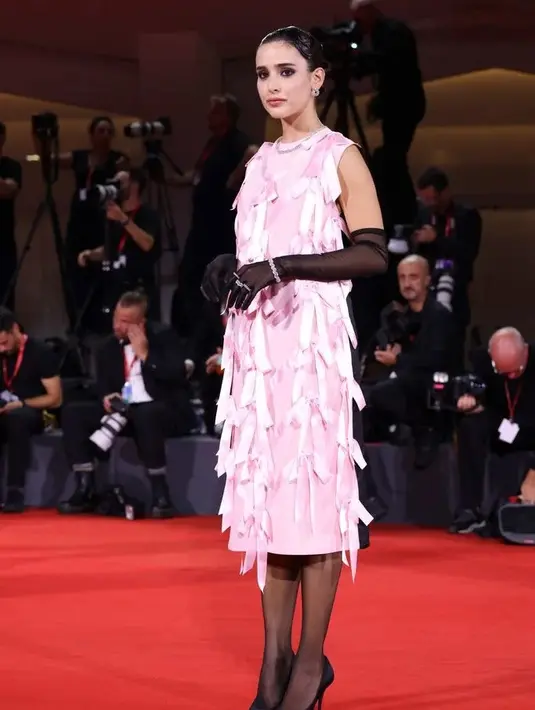 Livia Nunes Marques membawa estetika genit ke tingkat yang lebih tinggi dalam gaun Prada berhias pita berwarna merah muda. Ia memadukannya dengan sepasang celana ketat tipis dan sarung tangan yang senada. [Foto: Hello Magazine]