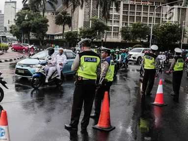 Polisi melakukan pengalihan arus lalu lintas terkait Malam Munajat 212 di Medan Merdeka Barat dan Utara, Jakarta, Kamis (21/2). Arus lalu lintas di sekitar kawasan Monas akan ditutup untuk mencegah kemacetan. (Liputan6.com/Faizal Fanani)