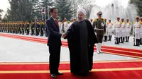 Presiden Joko Widodo berjabat tangan dengan Presiden Hassan Rouhani saat tiba di Istana Saadabad, Rabu (14/12). Dalam kunjungannya, Jokowi juga menghadiri jamuan makan siang. (AFP Photo/Atta Kenare)