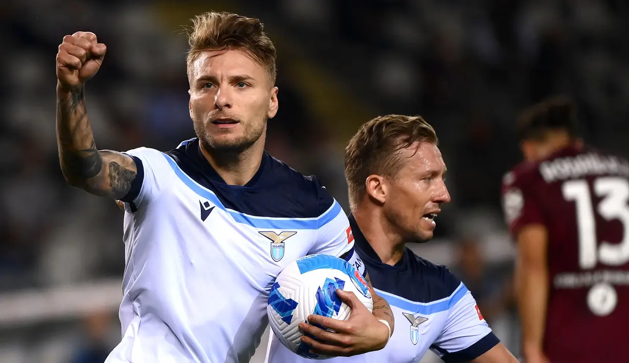 Ciro Immobile berhasil membubuhkan namanya di pemuncak top skor Liga Italia 2021/2022 hingga pekan ini. Ia tercatat telah mengoleksi enam gol dan dua assist dari enam penampilannya, selisih satu angka dengan Edin Dzeko di Inter Milan. (AFP/Marco Bertorello)