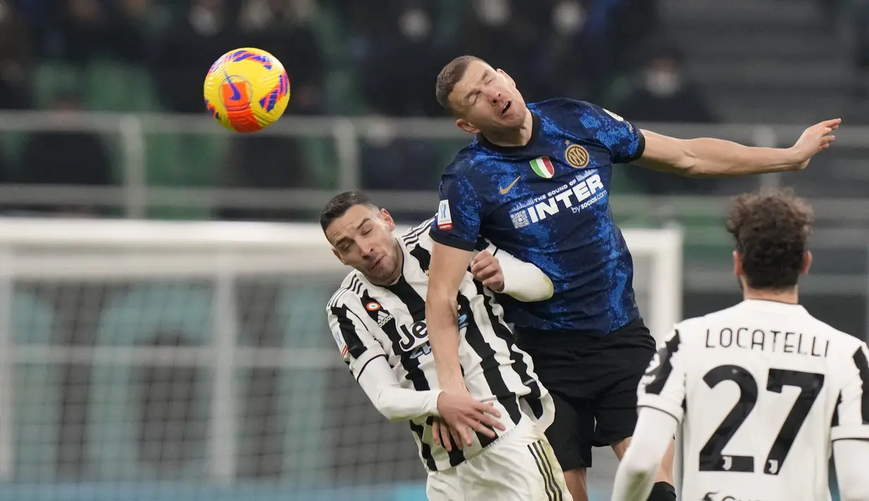 Bek Juventus, Mattia De Sciglio berebut bola udara dengan penyerang Inter Milan, Edin Dzeko pada pertandingan final Piala Super Italia 2021 di Stadion San Siro di Milan, Italia, Kamis (13/1/2022). Inter Milan menang tipis atas Juventus 2-1 lewat perpanjangan waktu. (AP Photo/Luca Bruno)