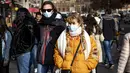 Orang-orang dengan masker melintasi jalan di pusat kota Amsterdam, Belanda, Rabu (3/11/2021). Dengan aturan terbaru, pemerintah Belanda mewajibkan penggunaan masker di ruang-ruang publik seperti tempat perbelanjaan, perpustakaan, salon, stasiun kereta, hingga rumah sakit. (Ramon van Flymen/ANP/AFP)