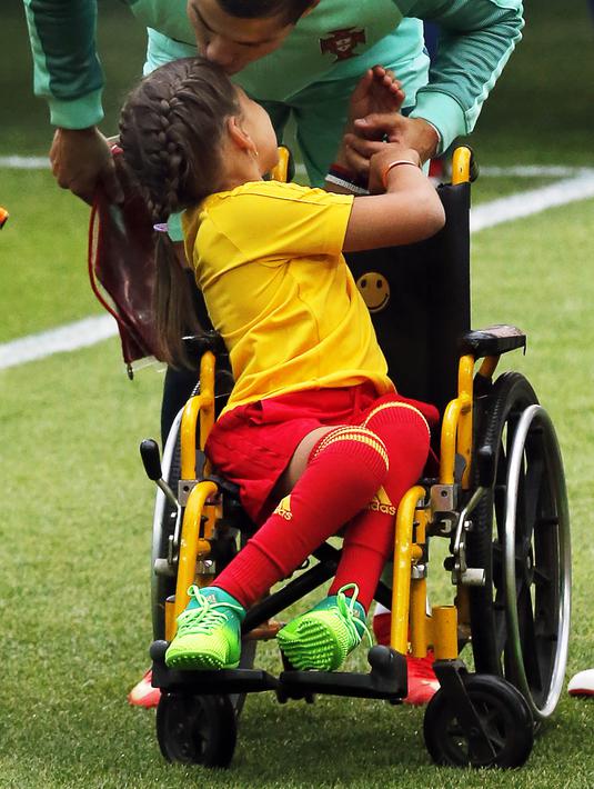 Bintang Portugal, Cristiano Ronaldo, mencium seorang anak sebelum laga Grup A Piala Konfederasi melawan Rusia di Stadion Spartak, Moskow, Rabu (21/6/2017). (EPA/Sergei Ilnitsky)