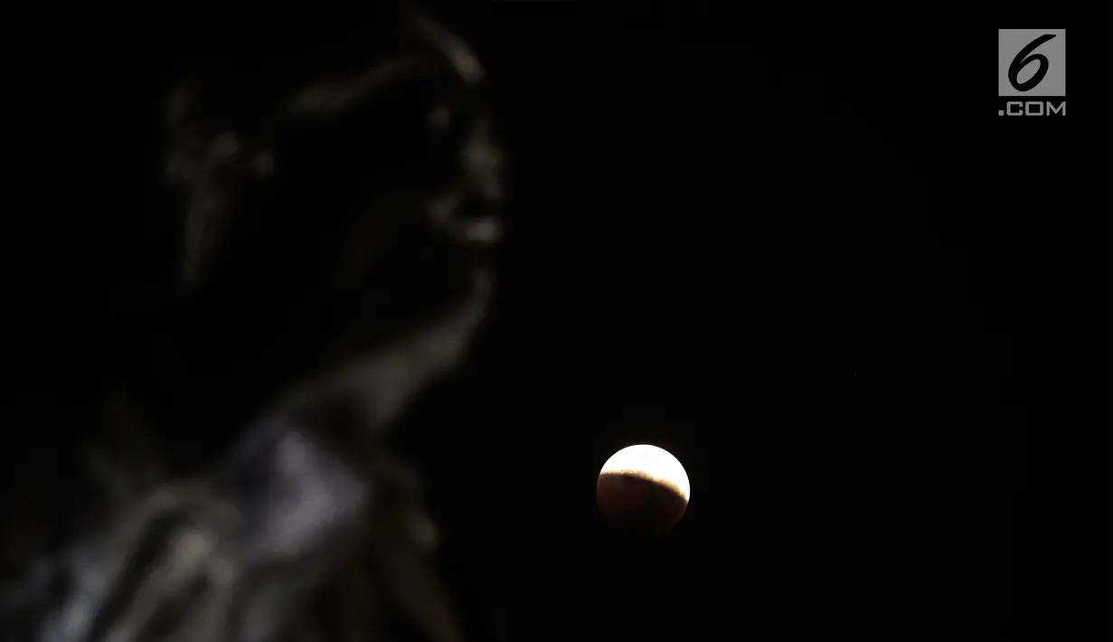 Foto fenomena gerhana bulan total di kota Jakarta, Sabtu (28/7). Gerhana bulan total "Micro Blood Moon" tersebut merupakan yang terlama pada abad ini dengan total waktu termasuk fase penumbra dan parsial selama enam jam lebih. (Liputan6.com/Johan Tallo)