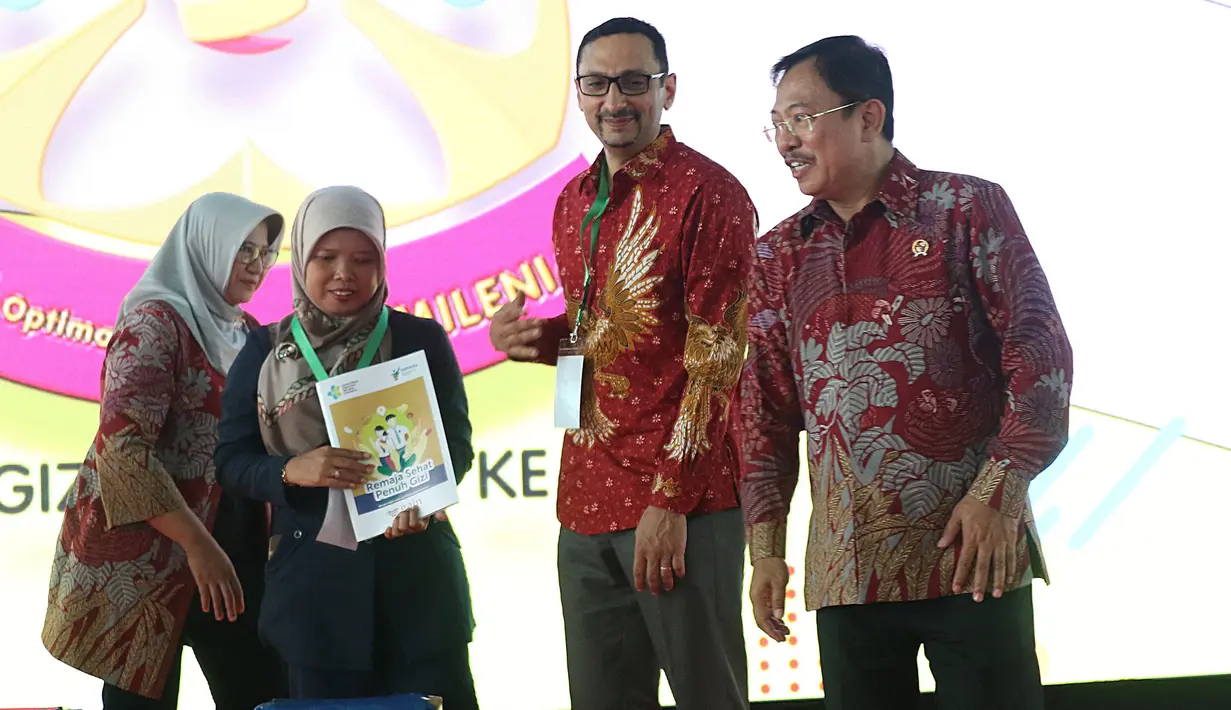Menteri Kesehatan, Terawan Agus Putranto (kanan) usai menyerahkan buku edukasi Remaja Sehat Penuh Gizi kepada  perwakilan instansi pemerintah dan guru saat peringatan Hari Gizi Nasional ke-60 di halaman Gedung Kementerian Kesehatan, Jakarta, Selasa (28/1/2020). (Liputan6.com/Angga Yuniar)