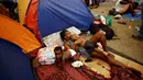 Migran asal Afrika yang terdampar di Kosta Rika beristirahat di dekat tenda miliknya di kamp darurat di perbatasan antara Kosta Rika dan Nikaragua, di Penas Blancas, Kosta Rika, (14/7). (REUTERS / Juan Carlos Ulate)