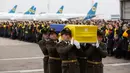 Prajurit Penjaga Kehormatan membawa jenazah 11 warga Ukraina yang tewas dalam insiden jatuhnya pesawat Ukraine International Airlines di Iran (8/1) lalu, Bandara Boryspil Kiev, Ukraina, Minggu (19/1/2020). 176 penumpang dan awak tewas dalam tragedi tersebut.(Ukrainian Presidential Press Service/AFP)