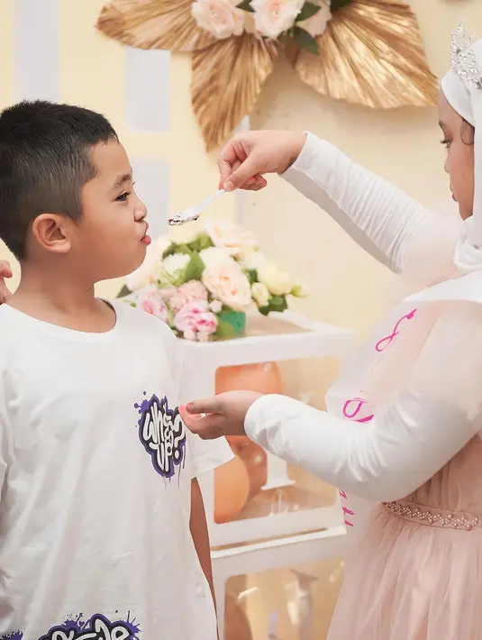 Beri suapan kue untuk sang adik. Maryam anak Oki yang sering mendampingi saat ibundanya berdakwah. [Instagram/okisetianadewi]
