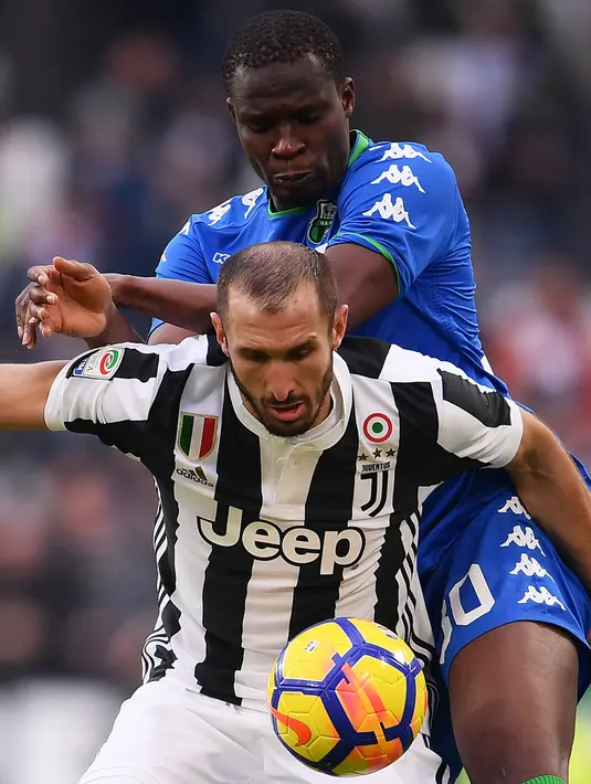 Pemain Juventus, Giorgio Chiellini (depan) berebut bola dengan pemain Sassuolo, Khouma Babacar pada lanjutan Serie A di Allianz Stadium, Turin (4/2/2018). Juventus menang 7-0. (AFP/Marco Bertorello)