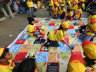 Anak-anak bermain ular tangga pada acara Kampanye Nasional bertajuk Cegah Stunting Itu Penting di Lapangan Gasibu, Bandung, Minggu (18/11). Kampanye bersama Energen menunjukkan kepedulian terhadap kasus balita bertubuh pendek. (Liputan6.com/HO/Bon)