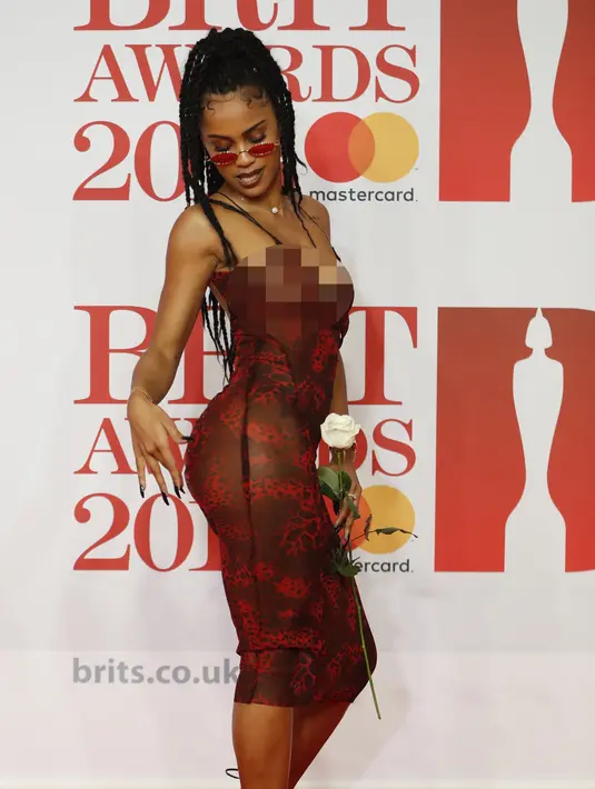 Pose Diana De Brito, yang dikenal sebagai IAMDDB berpose di karpet merah saat tiba menghadiri BRIT Awards 2018 di London, Inggris (21/2). (AFP Photo/Tolga Akmen)