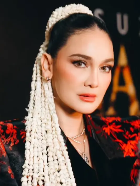 Saat premier film terbarunya, Luna Maya tampil dengan gaya rambut sanggul modern mengenakan ronce melati di rambutnya. [@snap.nuel/@claudianrh]