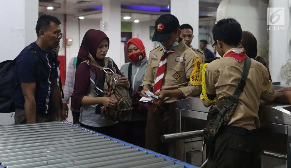 Anggota Pramuka membantu calon penumpang melakukan cek in elektronik di ruang tunggu menuju dermaga Pelabuhan Penyeberangan Merak, Banten, Sabtu (1/6/2019). Hingga Sabtu (1/6) pukul 08.00 WIB, tercatat 400.309 orang menyebrang dari pelabuhan Merak menuju Bakauheni. (Liputan6.com/Helmi Fithriansyah)
