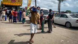 Seorang pria yang membawa tabung oksigen dari lokasi yang menyumbangkan oksigen gratis di Yangon, Myanmar pada 14 Juli 2021. Mereka putus asa mencari oksigen untuk menjaga orang yang dicintai tetap bernapas ketika gelombang corona covid-19 menerjang negara yang dilanda kudeta itu. (Ye Aung THU/AFP)