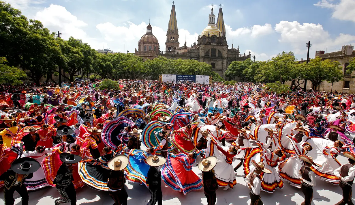 <p>Pasangan menari mengikuti irama musik tradisional mariachi untuk memecahkan Rekor Dunia Guinness di Guadalajara, Meksiko pada 24 Agustus 2019. Sebanyak 882 orang menari dengan kostum tradisional dalam upaya memecahkan rekor dunia untuk kategori tarian rakyat terbesar. (ULISES RUIZ/AFP)</p>