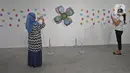 Pengunjung mengambil gambar karya yang dipajang dalam pameran Pulih di Pasar Seni, Ancol, Jakarta, Sabtu (14/11/20). Pameran PULIH merupakan bagian dari kampanye #PemulihanBersama yang diaktifkan Pasar Seni Ancol bersama dengan berbagai seniman dan tokoh seni budaya. (Liputan6.com/Herman Zakharia)