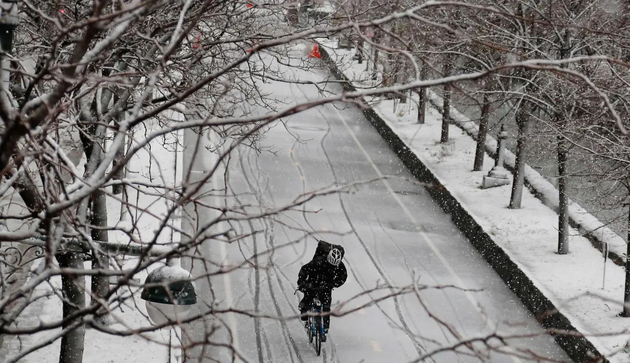 Pengendara sepeda melintasi sepanjang jalur Manhattan saat badai salju di New York City (7/3). Badai salju kedua yang melanda New York dalam waktu seminggu ini diperkirakan akan membawa angin kencang. (AP Photo / Bebeto Matthews)