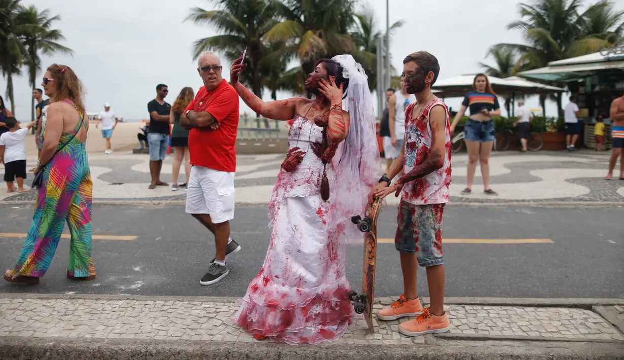Pengunjung memakai kostum dan dandanan menyerupai zombie dalam acara Zombie Walk di pantai Copacabana, Rio de Janeiro, Brasil, Jumat (2/11). Ribuan orang ini beraksi sebagai Zombie untuk memeriahkan peringatan Hari Para Arwah. (Mauro PIMENTEL/AFP)